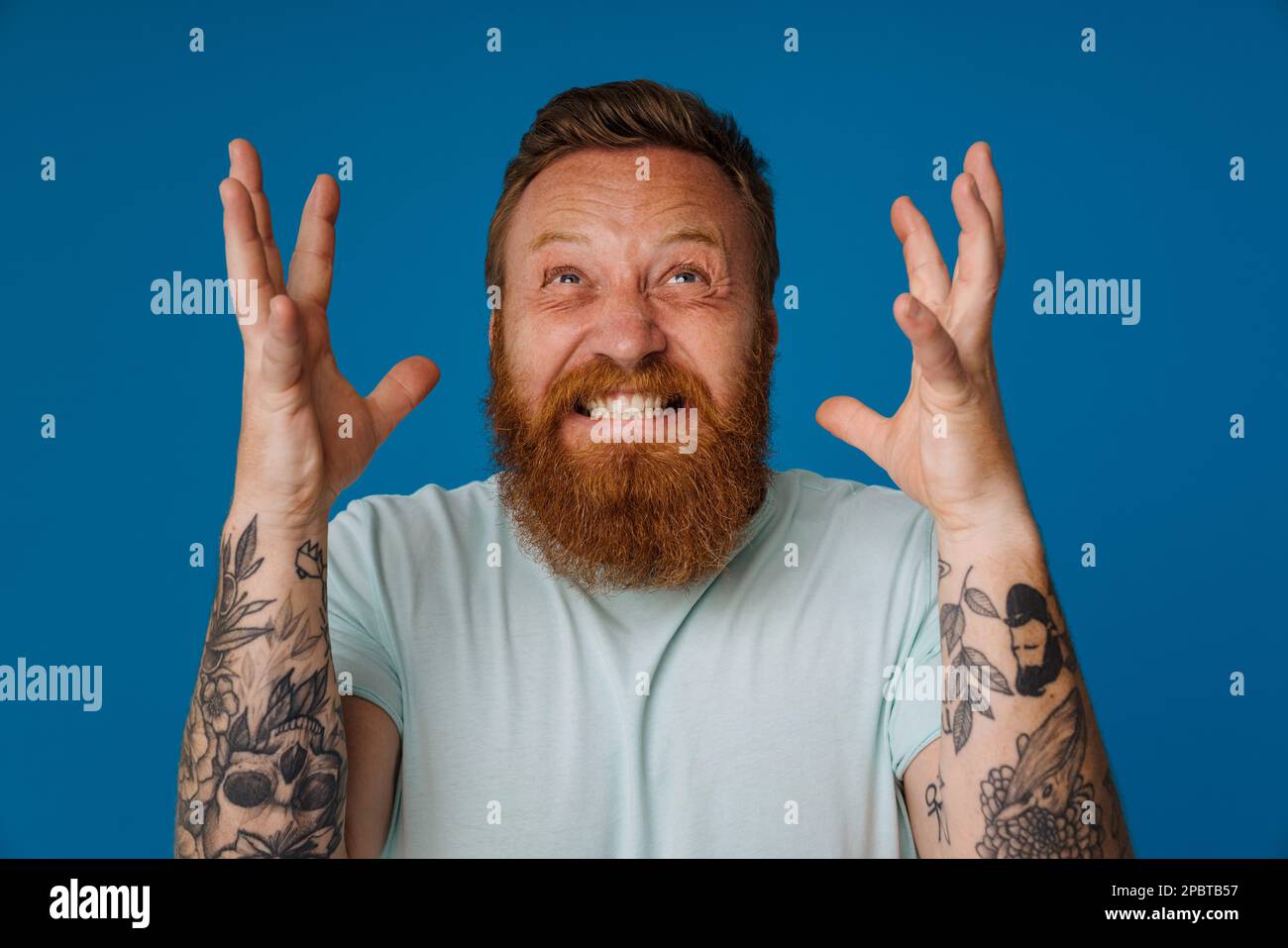 Adult bearded tattooed handsome stylish stressed man with clenched ...