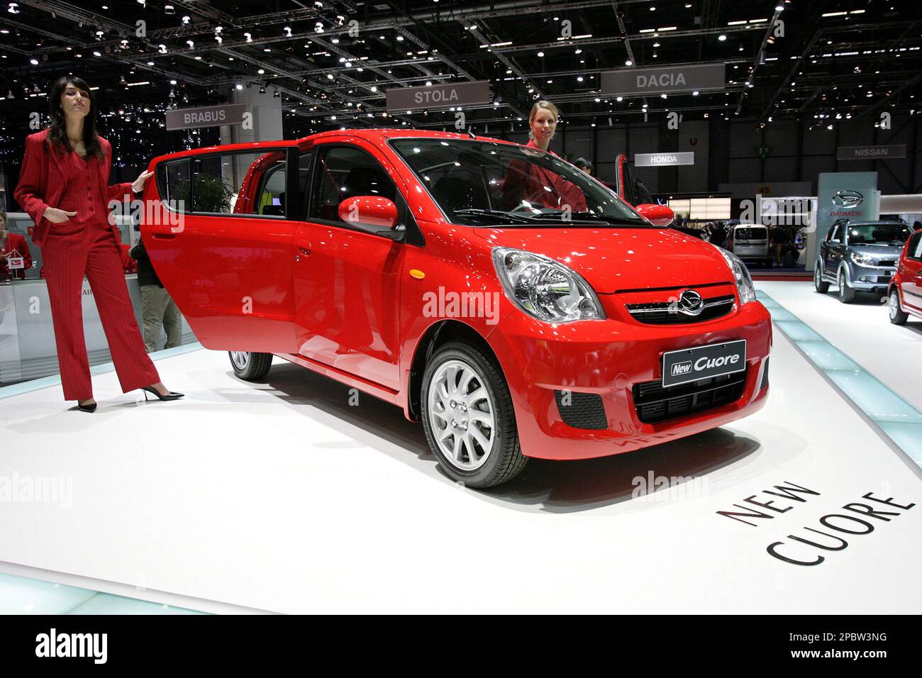Models stand next to a new Daihatsu Cuore eco top car during the press days  at the 77th Geneva International Motor Show in Geneva, Switzerland,  Wednesday, March 7, 2007. The Motor Show