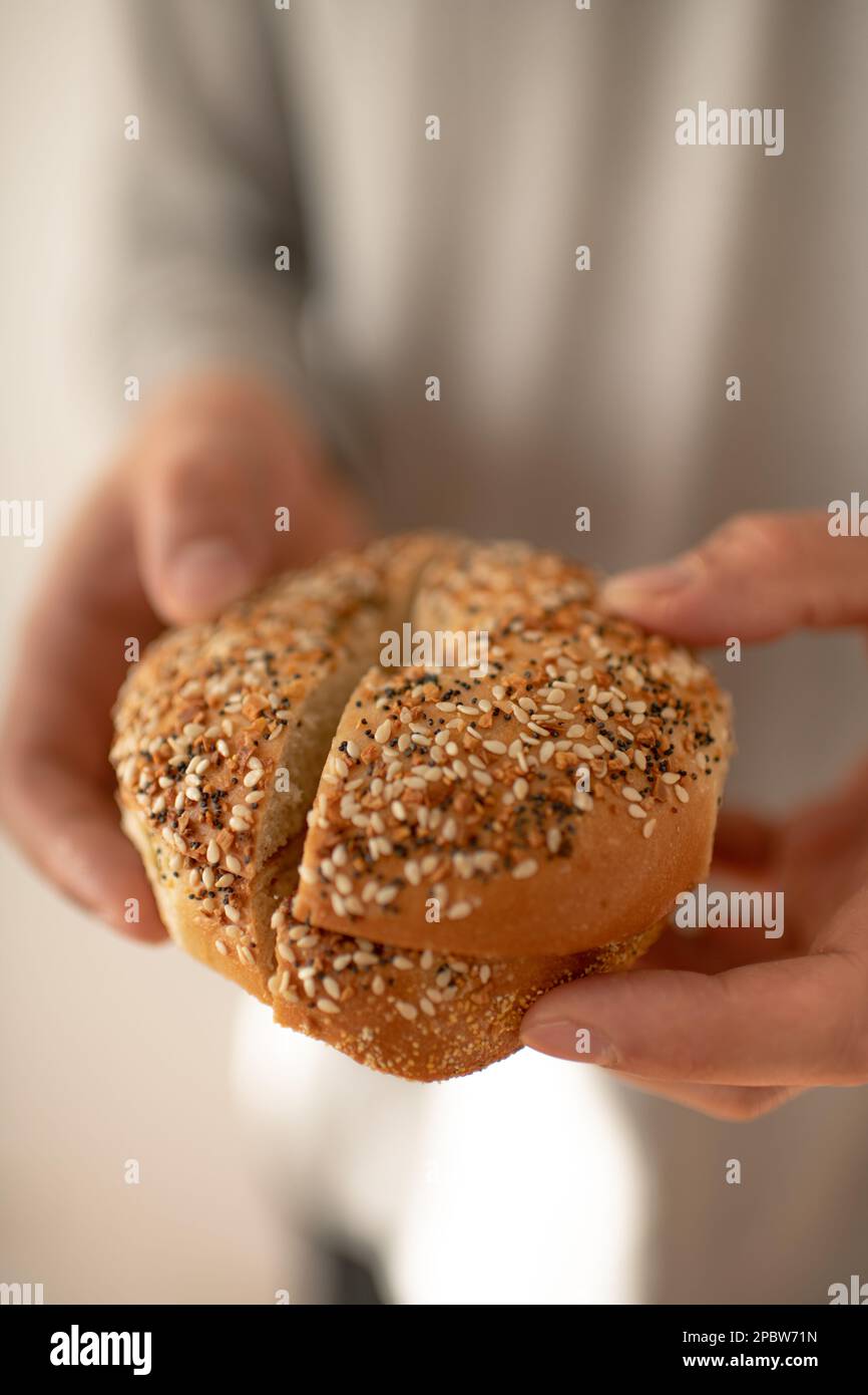 Person Holding An Everything Bagel To Eat for Breakfast Stock Photo
