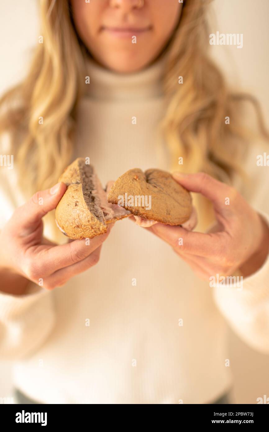 Woman Holding Banana Bagel with Strawberry Cream Cheese Stock Photo
