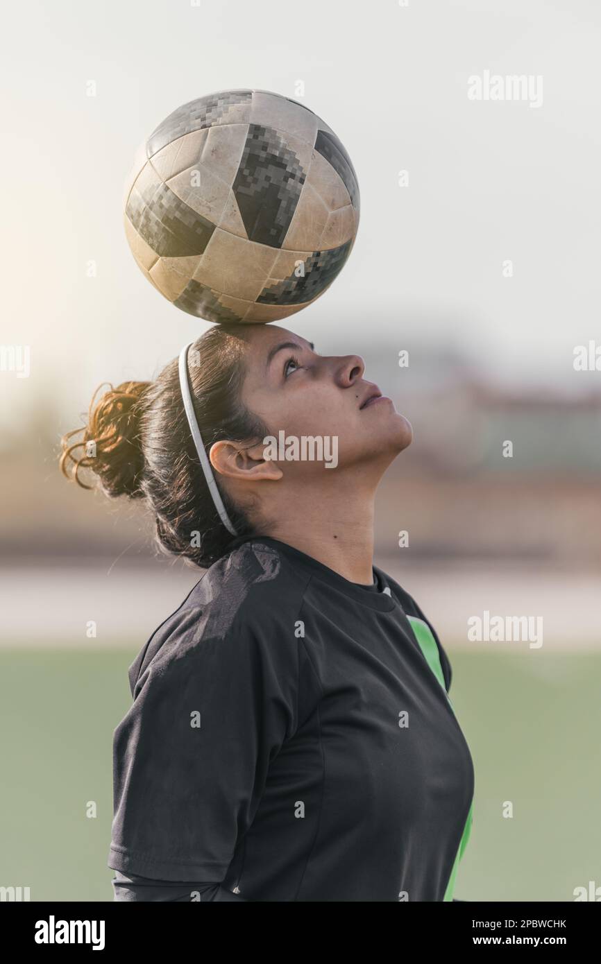 Young female soccer player balancing a ball on her head Stock Photo Alamy