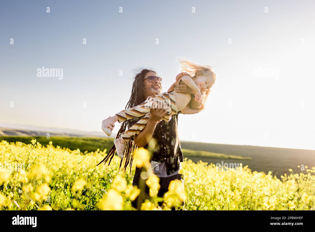 Uncle Holding Niece Up High in Flower Field in San Diego Stock Photo