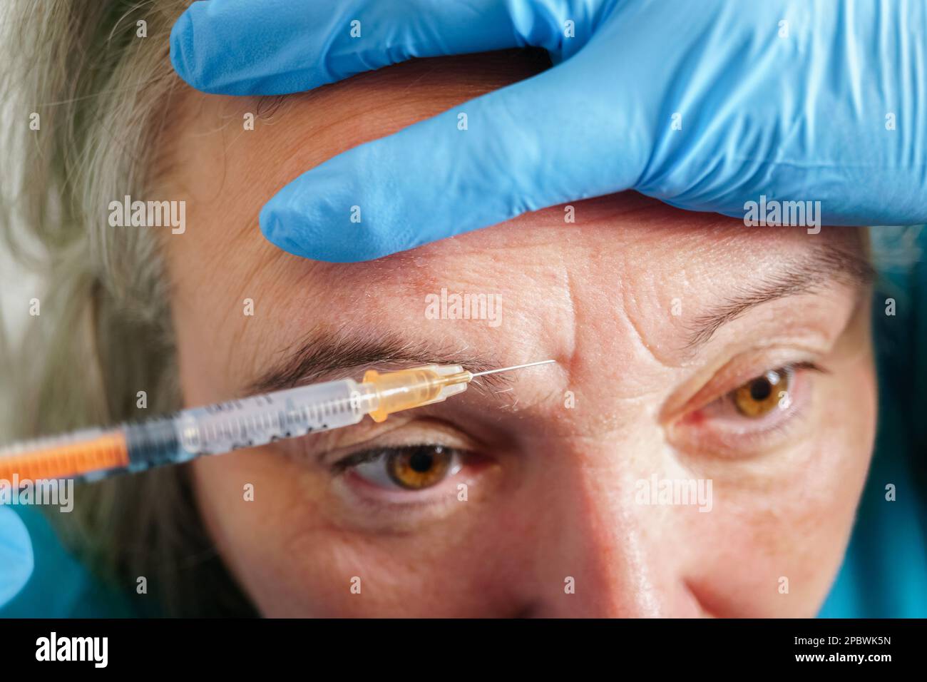 Aged lady having botox injecting procedure. Cosmetic treatment Stock Photo