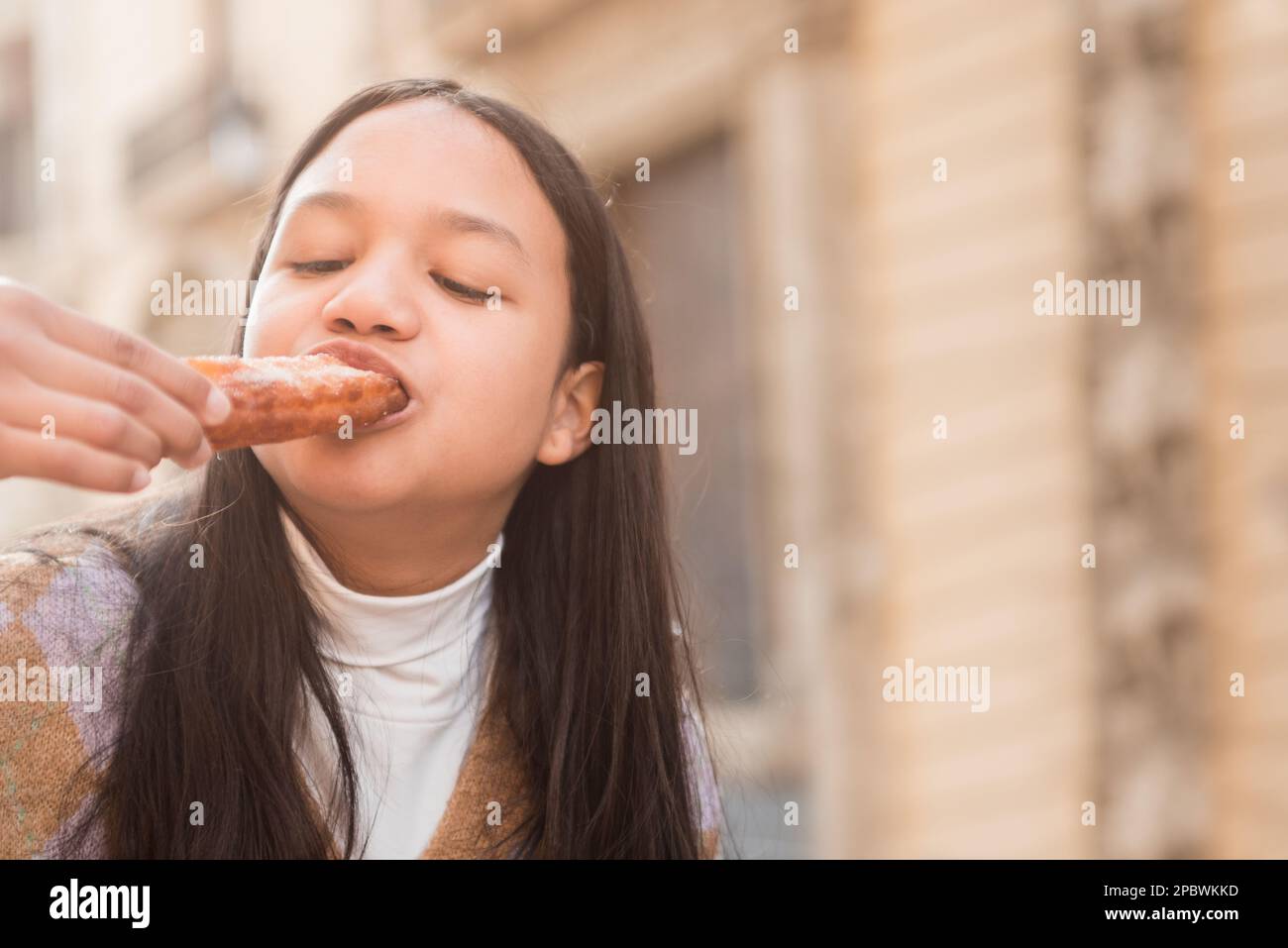 Close up young brunette teenager enjoying eating churros Stock Photo ...