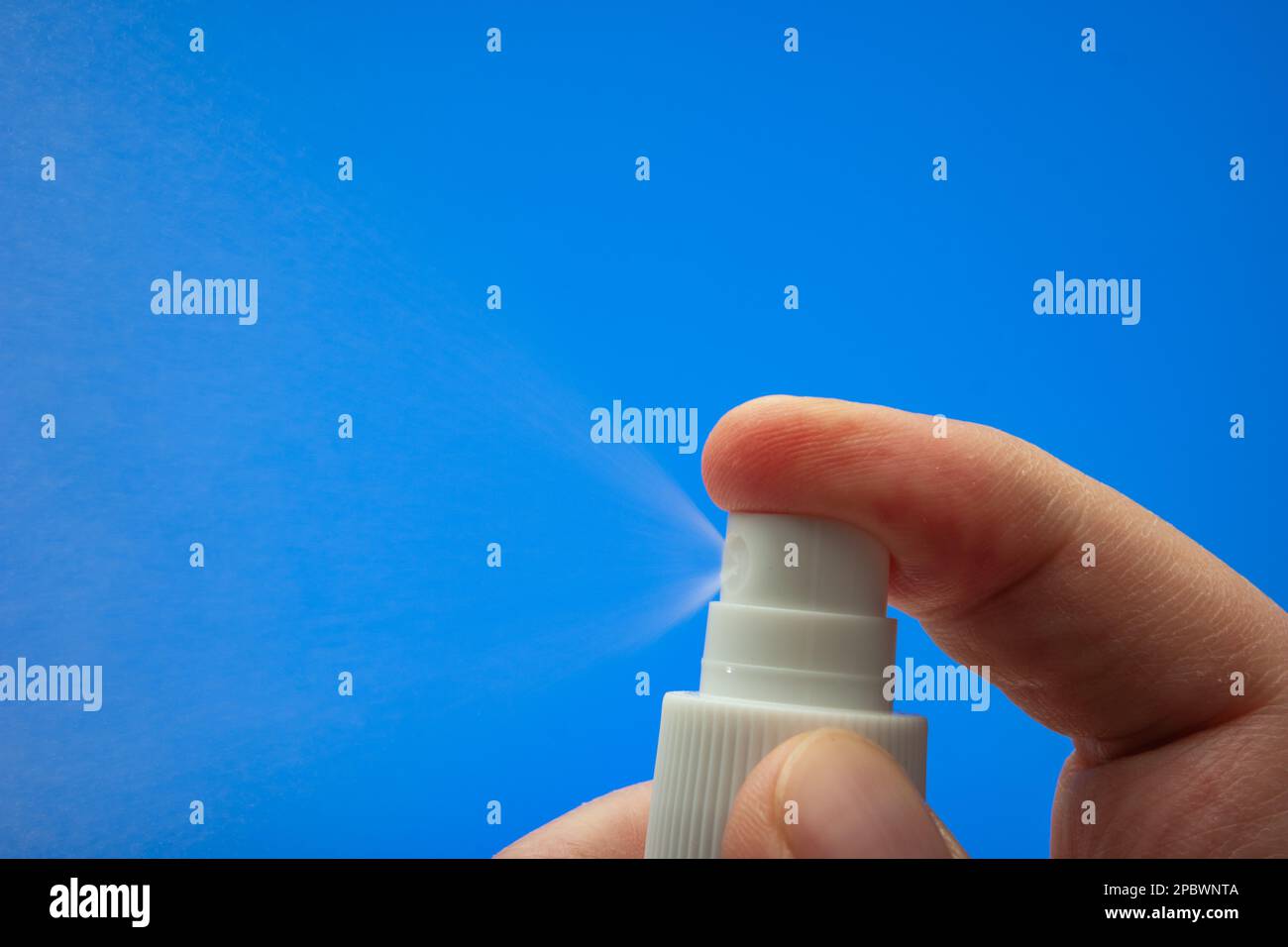 Small spray bottle pulverizer nozzle macro held by Caucasian male hand ...