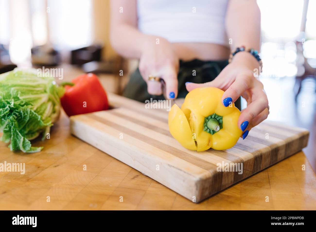 Hands with manicured nails chopping bright fresh veggies in kitchen Stock Photo