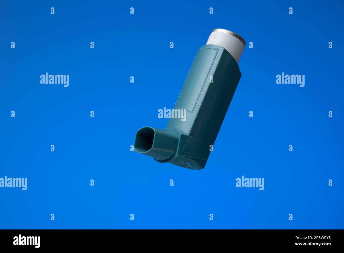 Asthma inhaler, generic, non-branded. Close up studio shot, isolated on blue background. Stock Photo