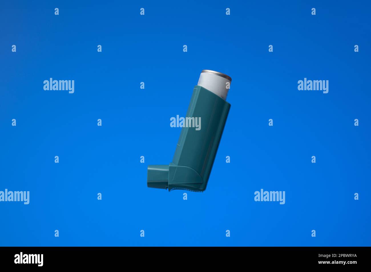 Asthma inhaler, generic, non-branded. Close up studio shot, isolated on blue background. Stock Photo