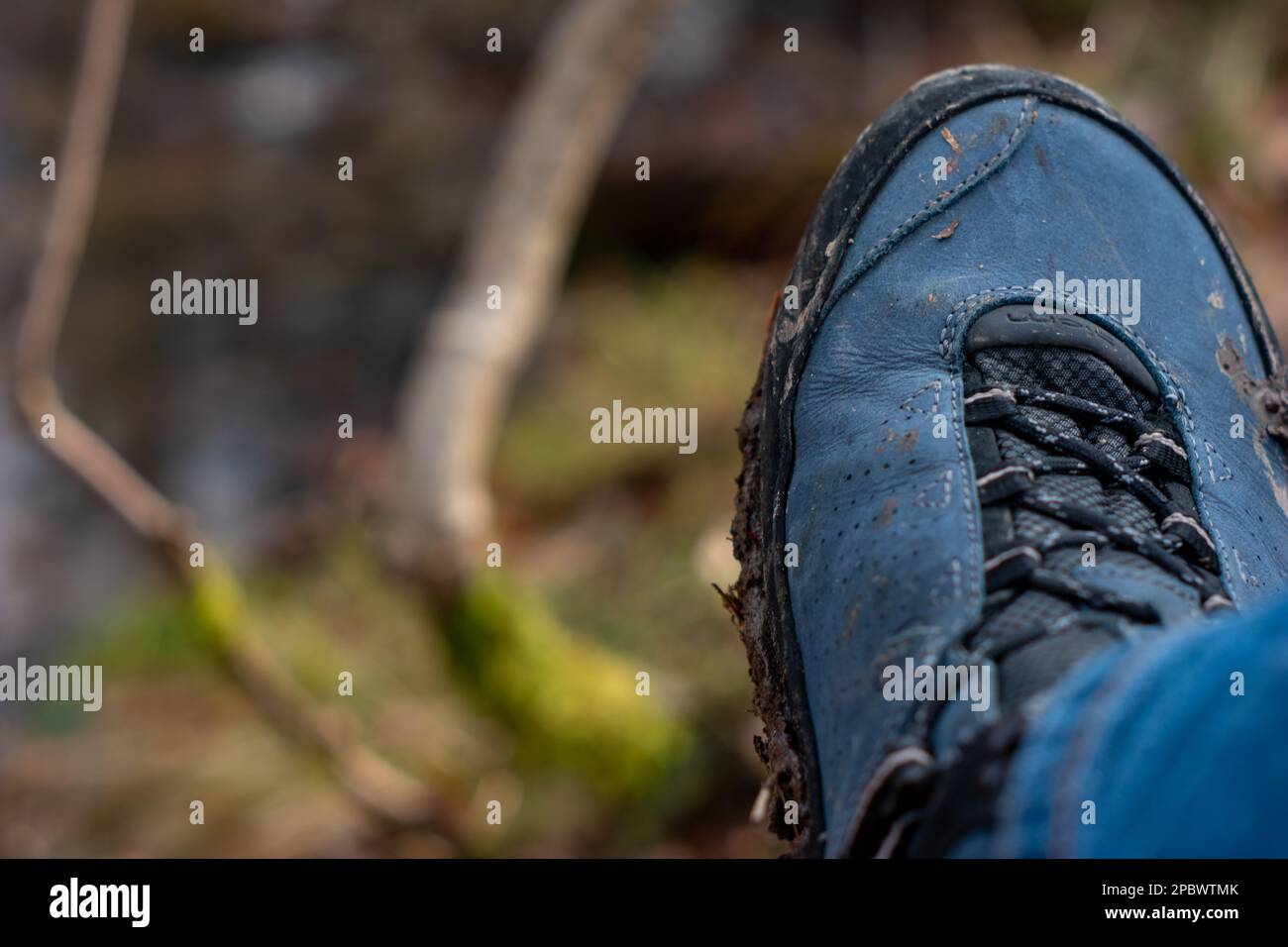 Mud covered hiking boots and sole outdoors. Daytime, no people, close ...