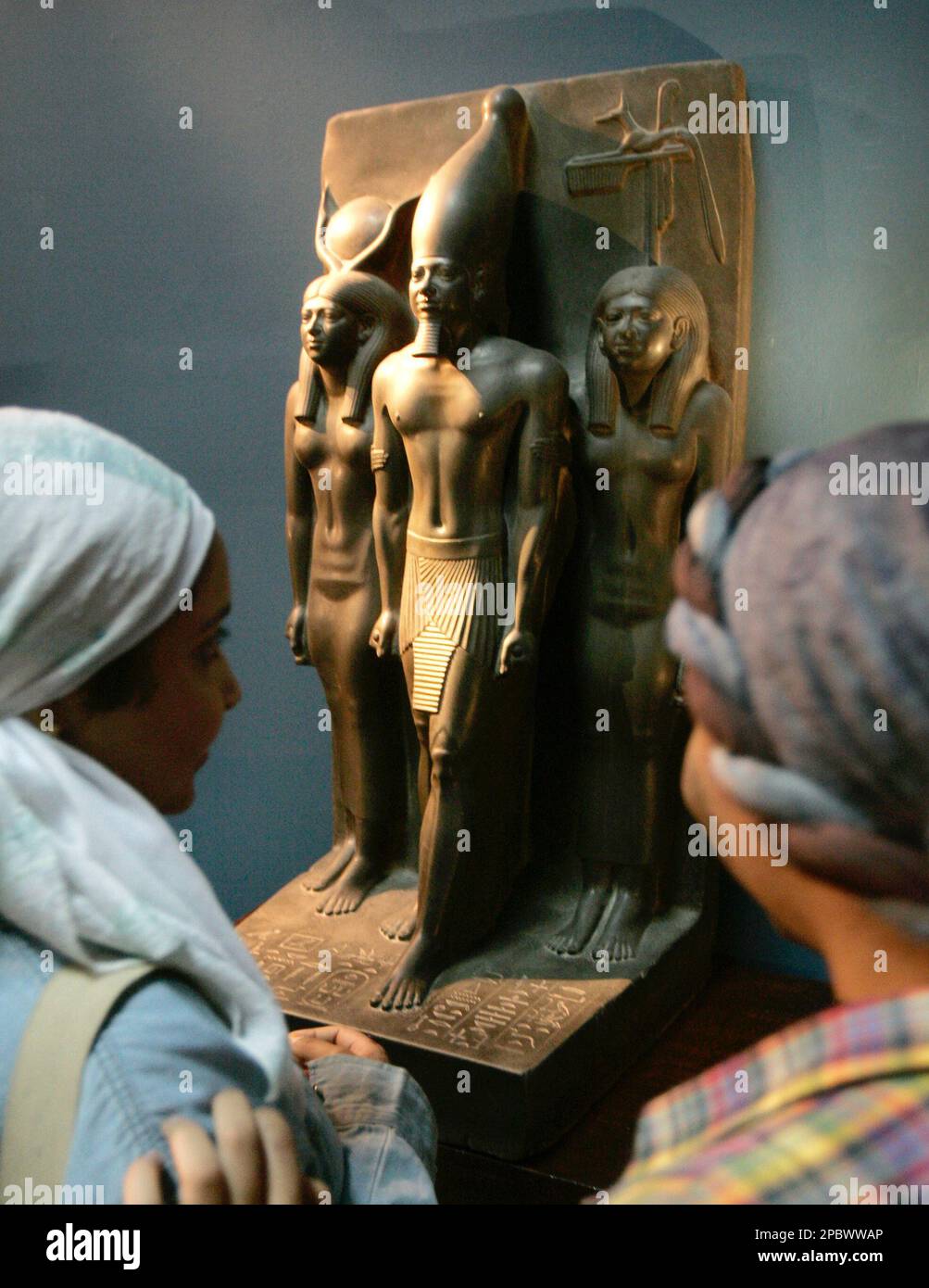 Visitors observe a triad statue of Menkaure, center, flanked by Hather