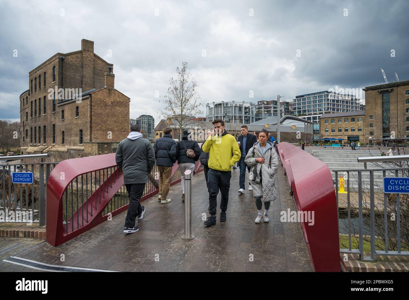 People crossing Esperance Bridge over the Regents Canal, Granary Square and Coal Drops Yard, Kings Cross, London, England, UK Stock Photo