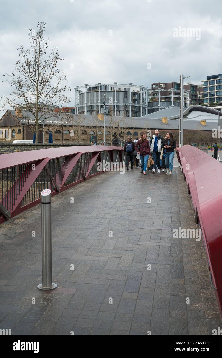 People crossing Esperance Bridge over the Regents Canal, Granary Square and Coal Drops Yard, Kings Cross, London, England, UK Stock Photo