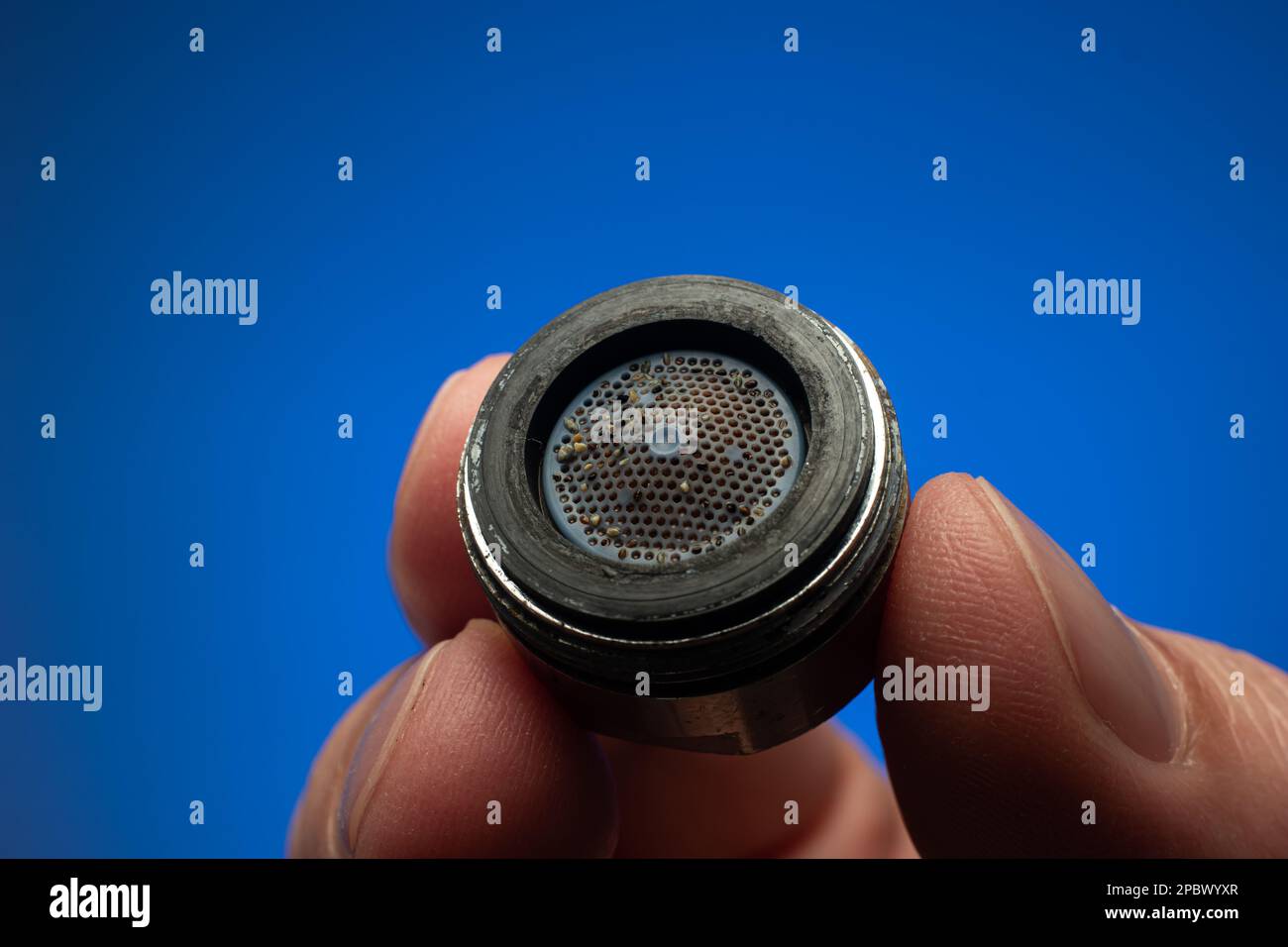 Old dirty limescale covered clogged up tap water faucet strainer or