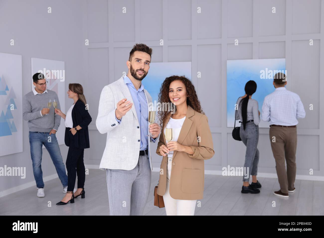 Couple with glasses of champagne at exhibition in art gallery Stock Photo