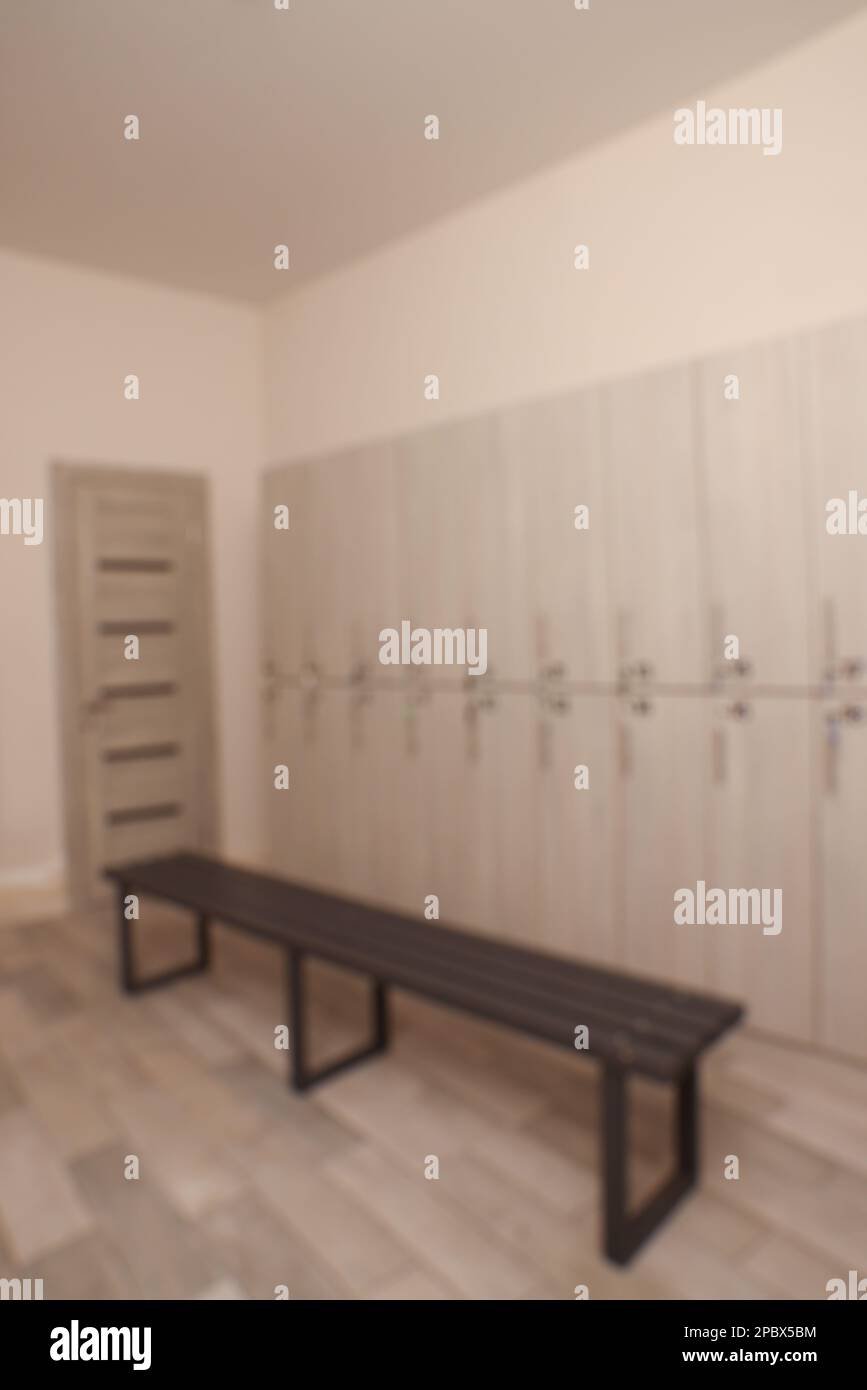 Blurred view of changing room with bench and lockers Stock Photo Alamy