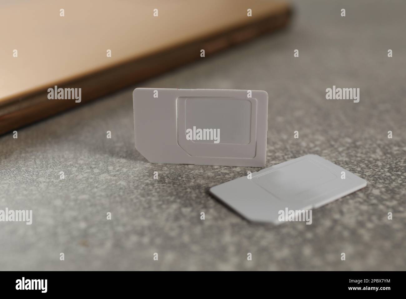 White multi SIM cards on grey table, closeup Stock Photo