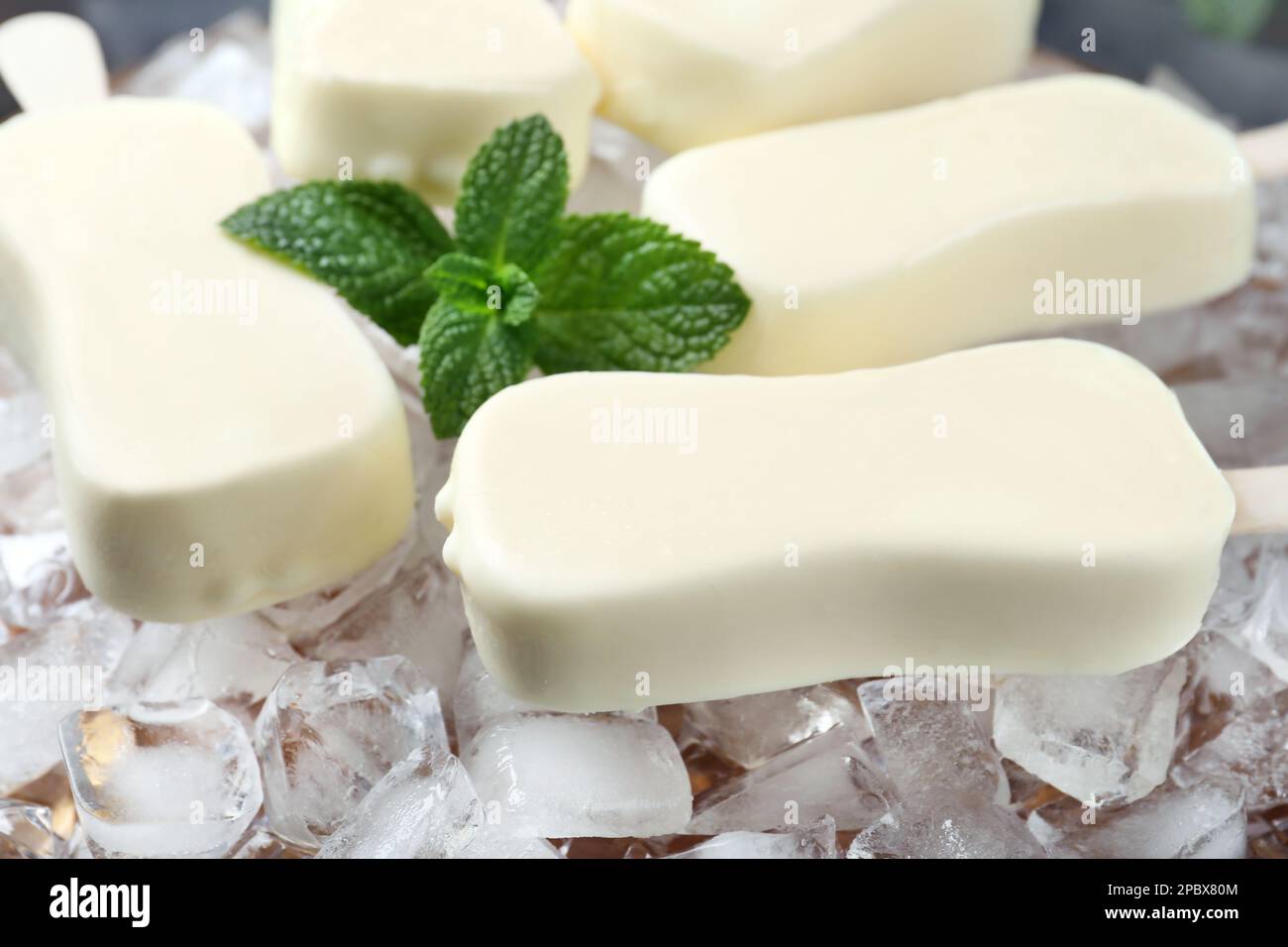 Glazed ice cream bars served with fresh mint on ice cubes, closeup Stock Photo