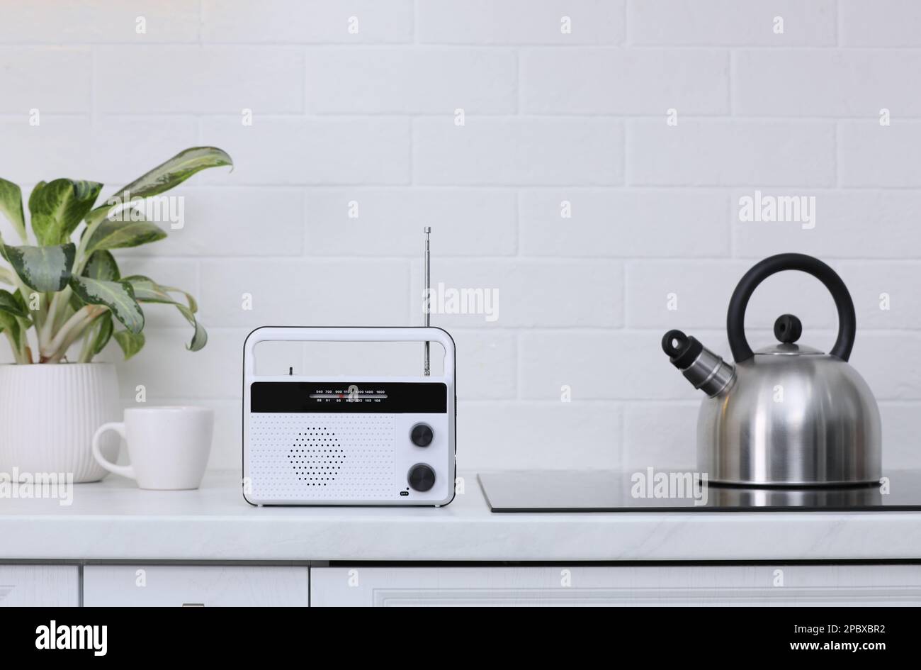 Stylish radio on kitchen counter near white brick wall Stock Photo - Alamy
