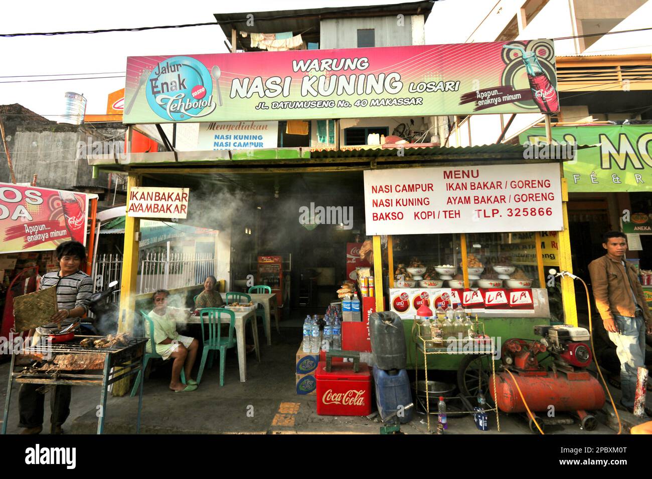 A scene on the side of Datu Musseng (Museng) Street, a locality with culinary vendors—some are traditionals—located near the coastal area of Makassar City, South Sulawesi, Indonesia. One of the 30 coastal cities in Indonesia which is estimated to be potentially affected by the rising sea level, Makassar has been considered by researchers and scientists as a city with significant environmental and social problems, mainly as results of the geomorphological condition and the policy on land use and coastal development, in particularly the reclamation projects currently conducted. Stock Photo