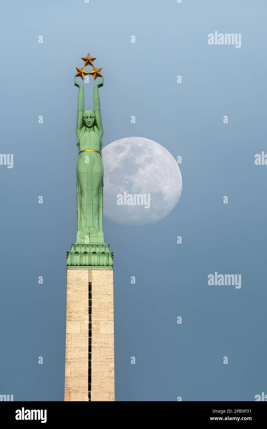 RIGA, LATVIA - 0CTOBER 28, 2012: Riga's monument of freedom dominates the city skyline at moonrise. Stock Photo
