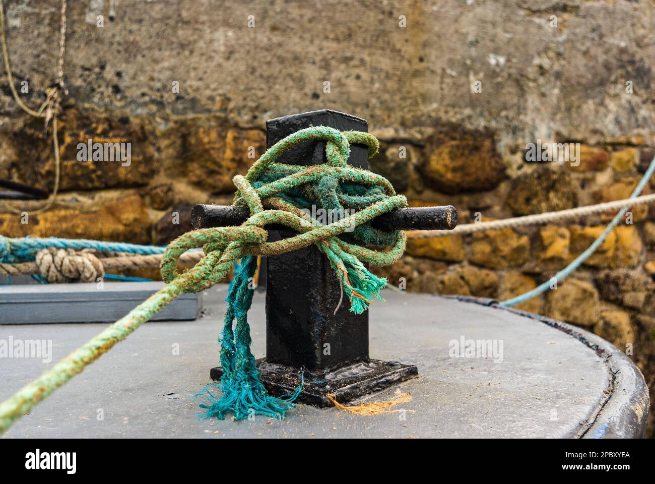 Metal mooring post on a fishing boat with a tangle of blue mooring ropes, UK Stock Photo