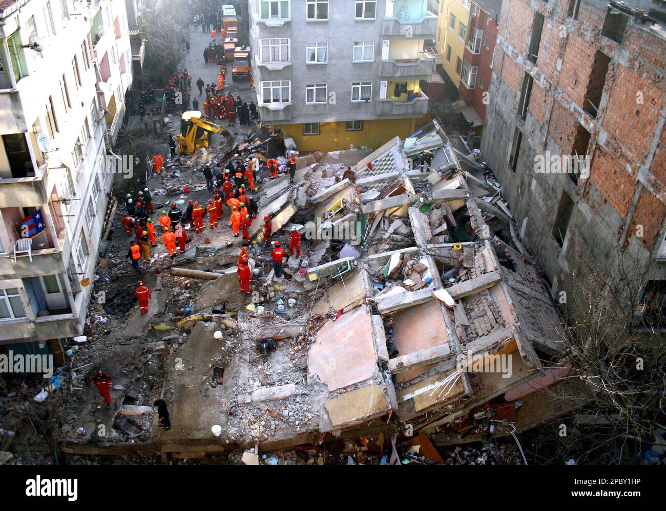 Rescue workers gather around a collapsed building in Istanbul, Turkey ...
