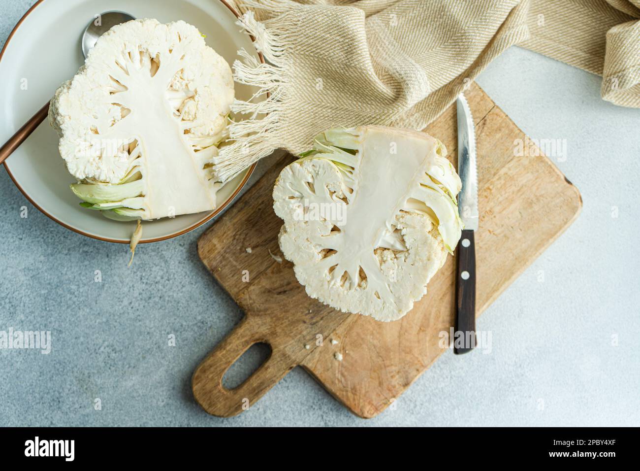 Raw cauliflower vegetable ready for cooking on concrete table Stock Photo