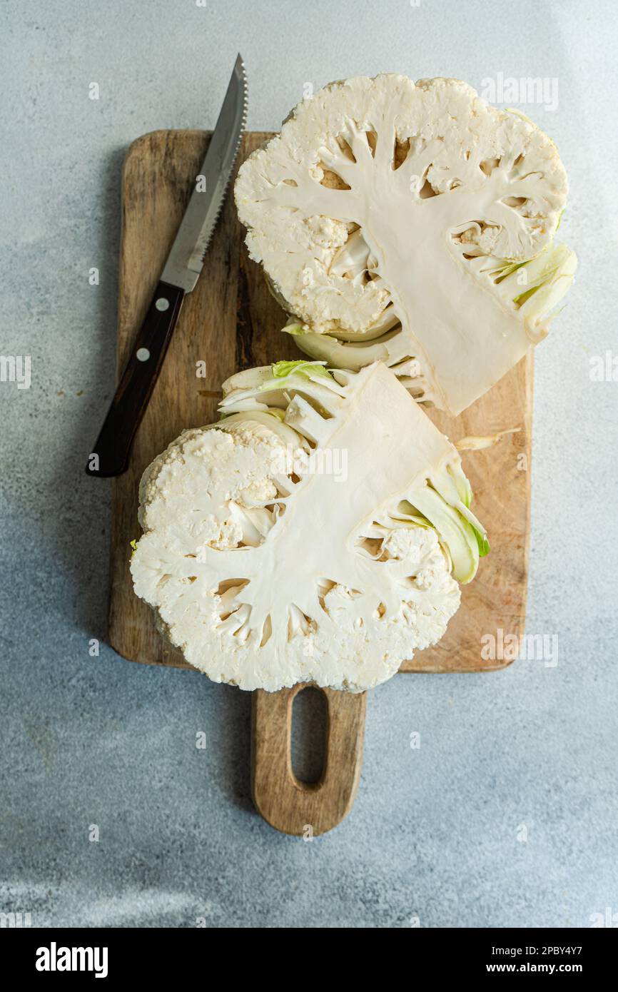 Raw cauliflower vegetable ready for cooking on concrete table Stock Photo