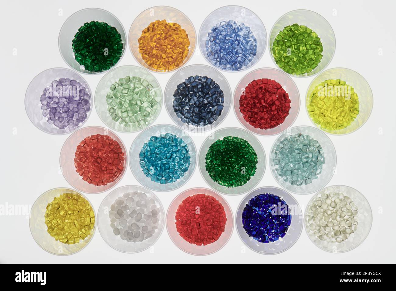 several transparent colored plastic resin granulates in test glasses in laboratory. Mass for injection molding and extrusion process Stock Photo