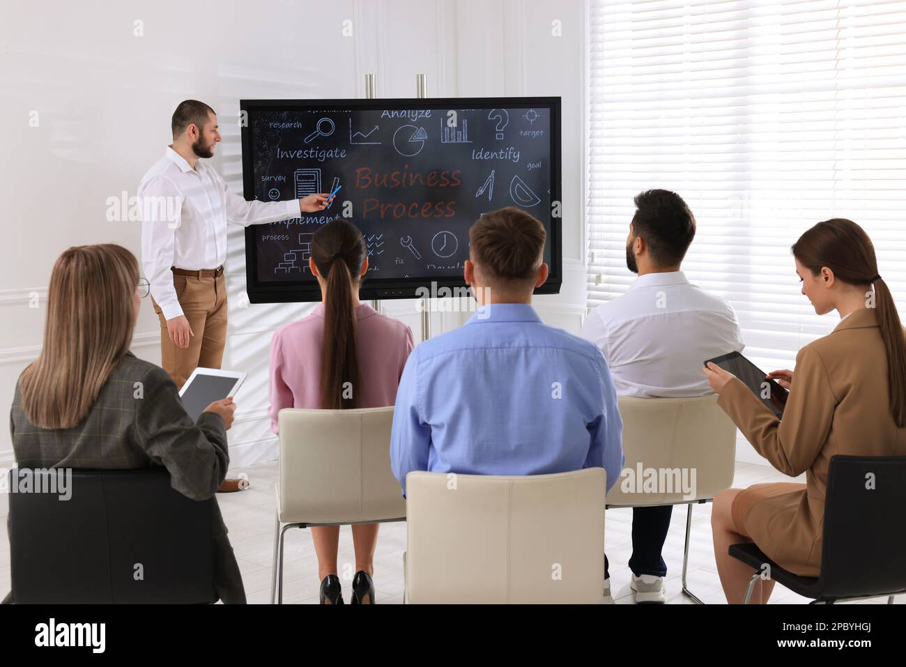 Business trainer using interactive board in meeting room during presentation Stock Photo
