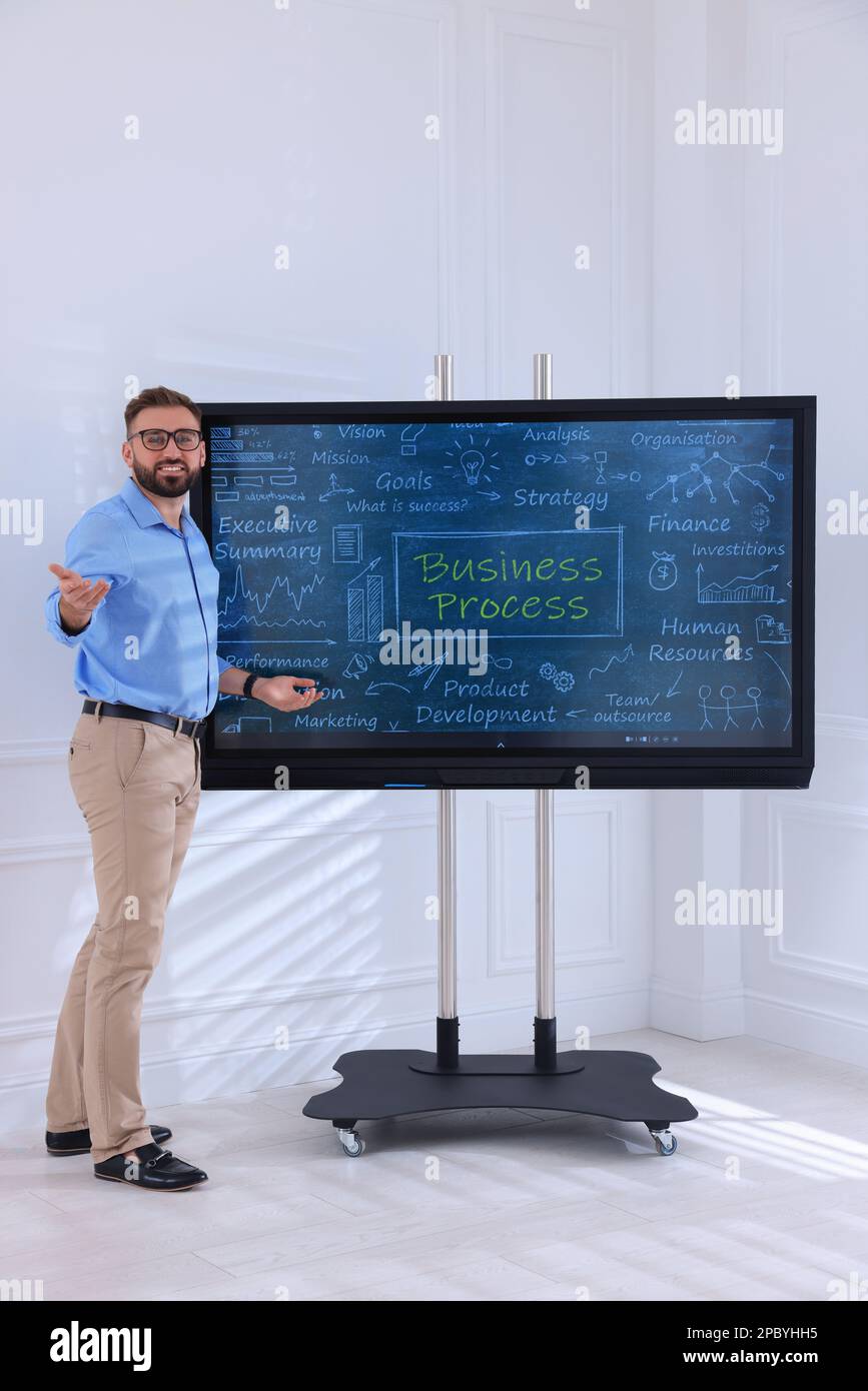 Business trainer using interactive board in meeting room Stock Photo