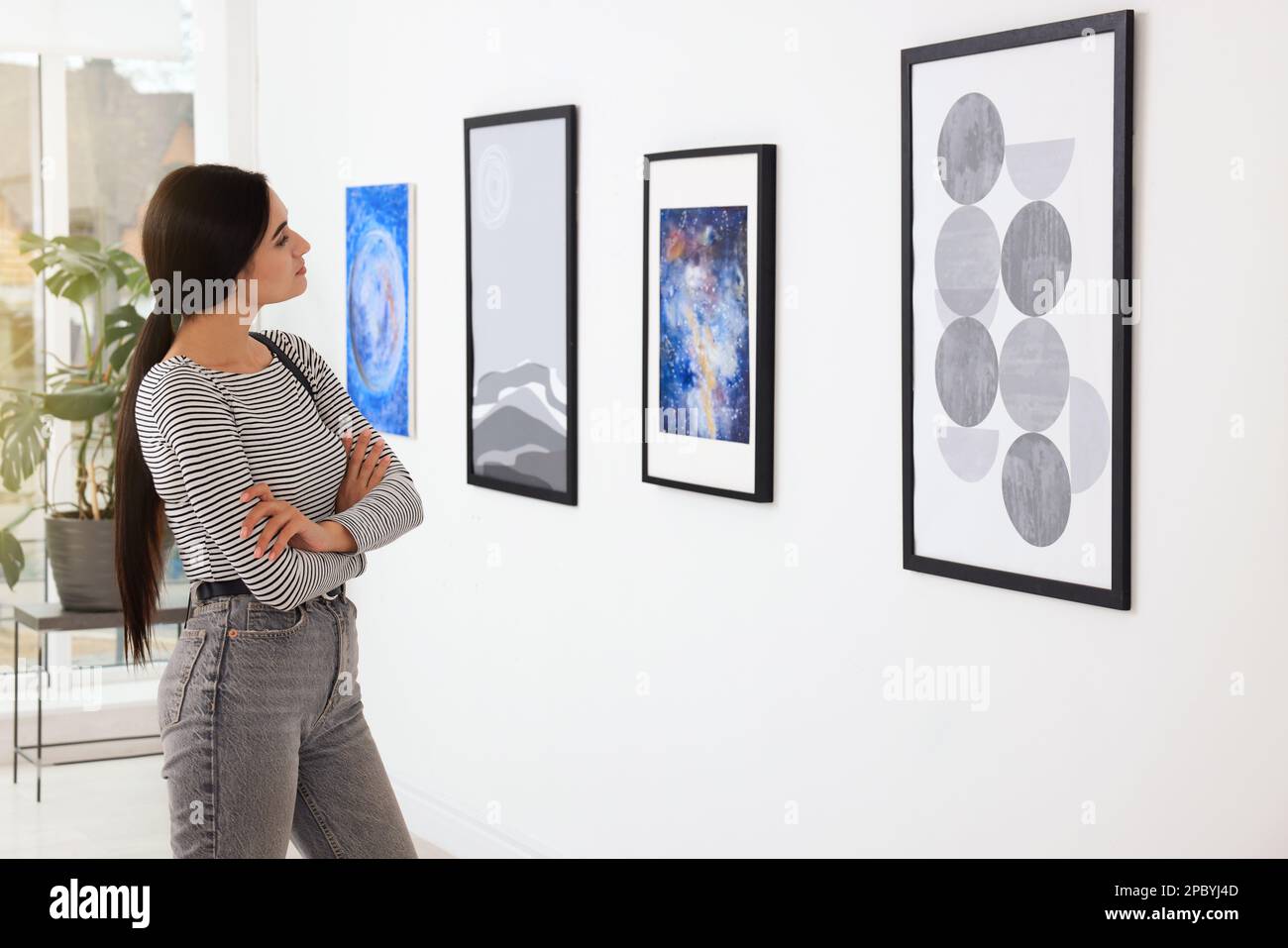 Thoughtful young woman at exhibition in art gallery Stock Photo - Alamy