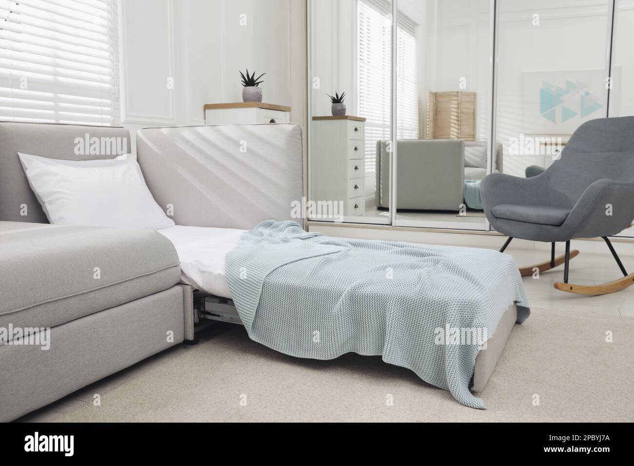 Stylish room interior with sleeper sofa. Additional place for guest ...