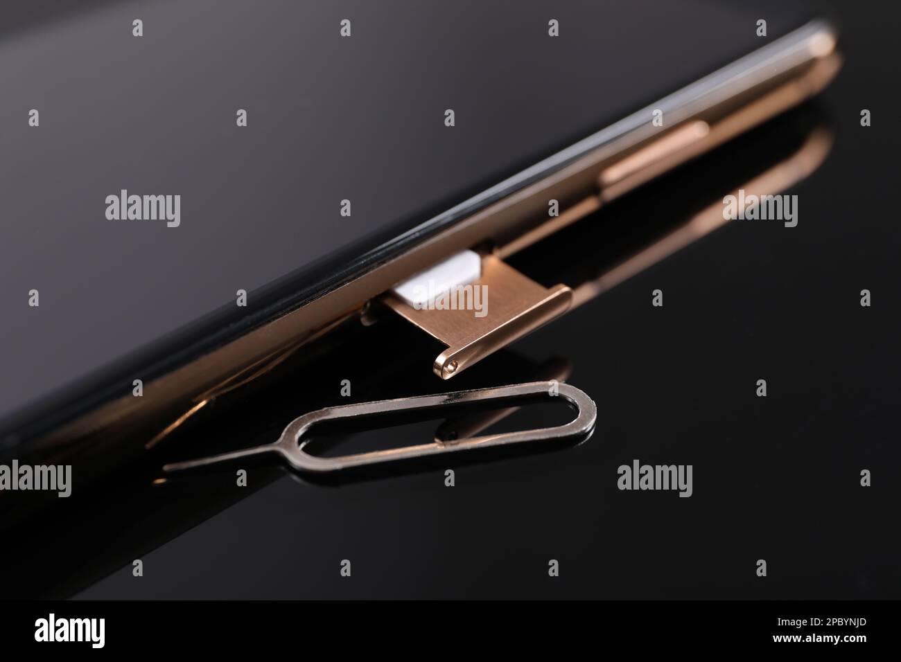 SIM card, smartphone and ejector on black background, closeup Stock Photo