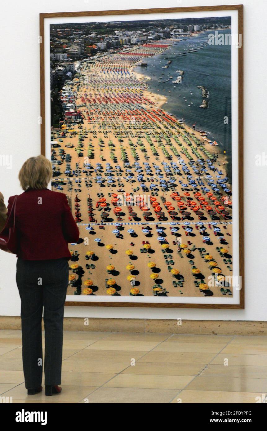 A woman stands in front of the picture 