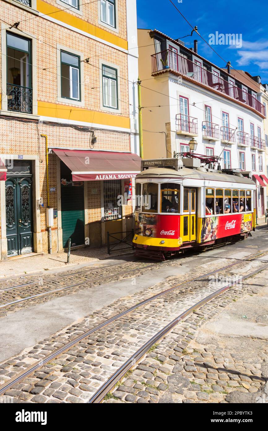Traditional red and yellow tram in a cobblestoned street of Lisbon, Portugal Stock Photo