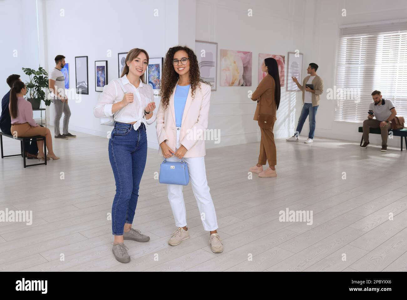 Young women at exhibition in art gallery Stock Photo - Alamy