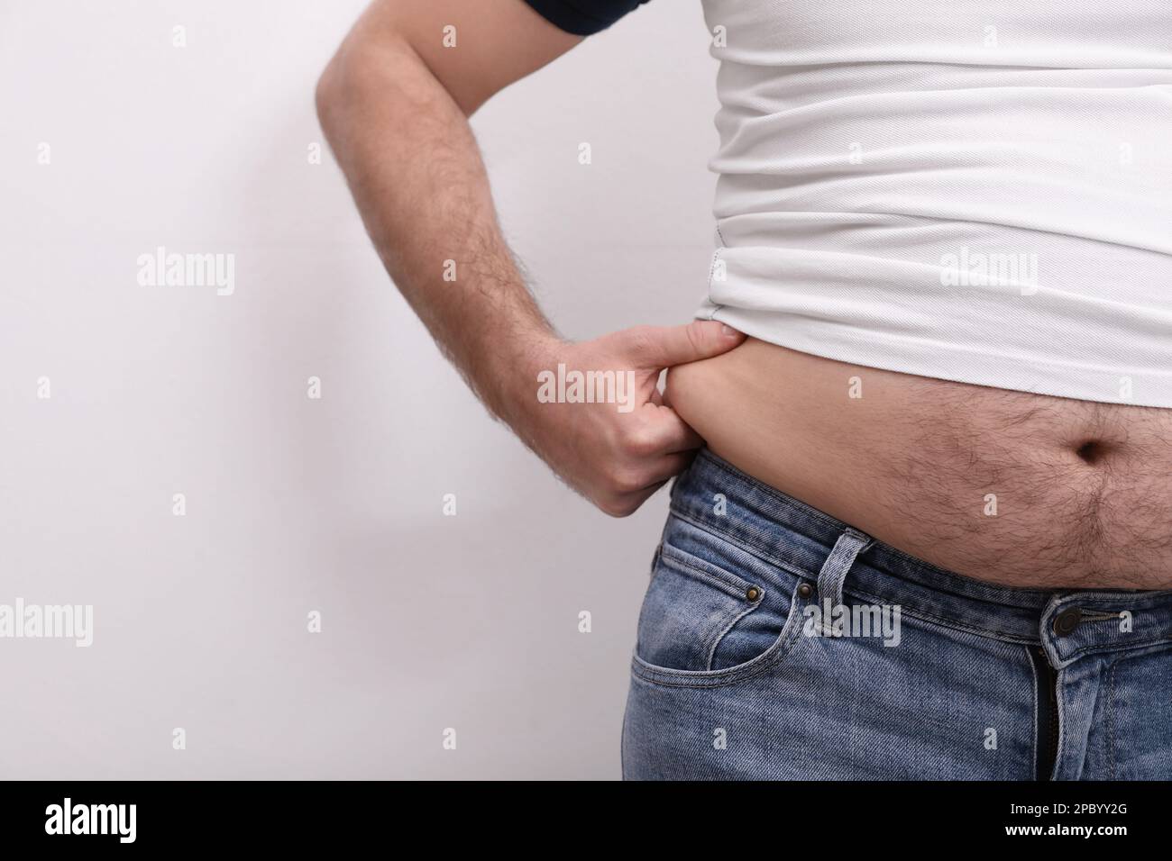 Man wearing tight t-shirt and jeans on white background, closeup ...