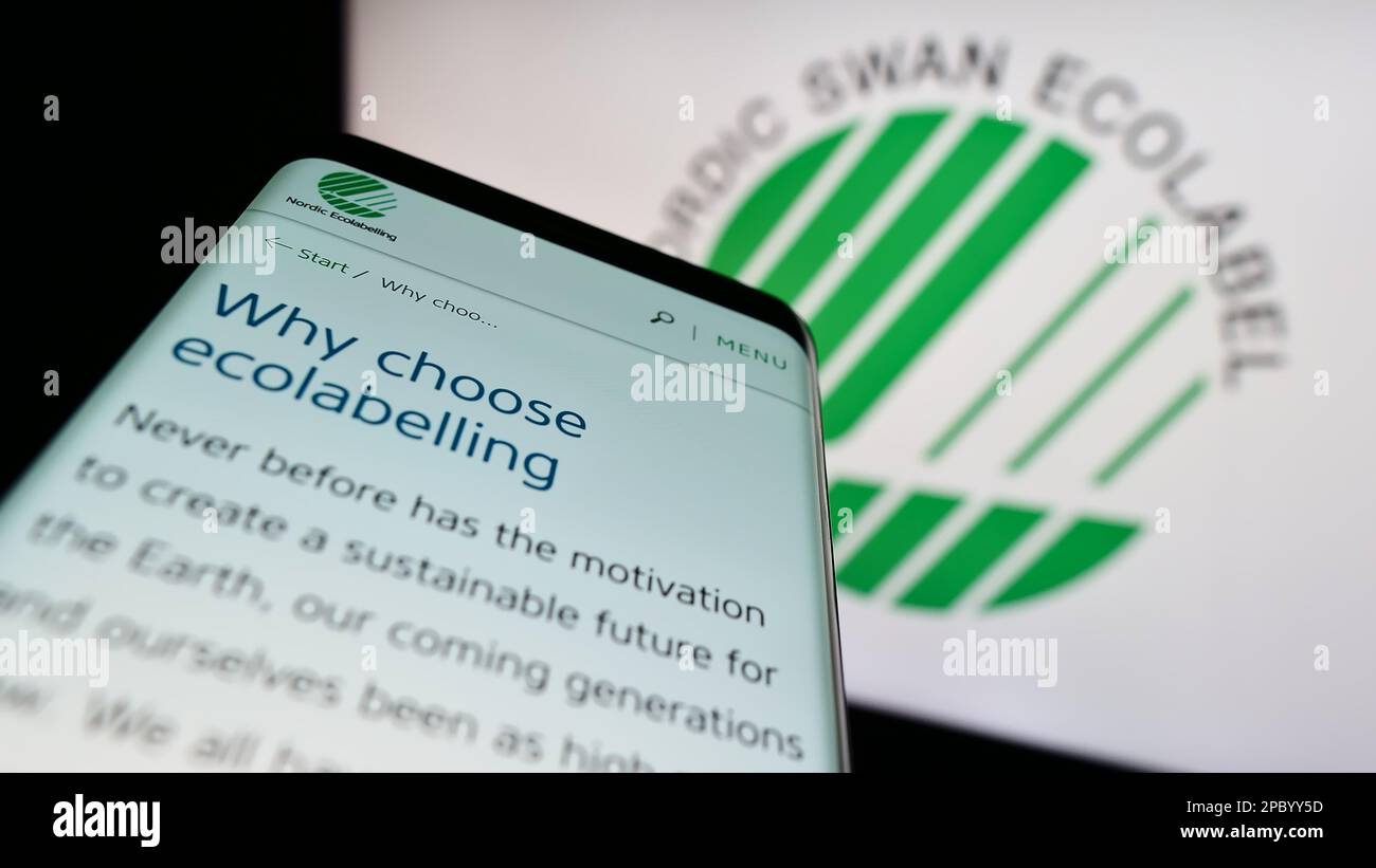 Smartphone with website of environmental certification Nordic Ecolabel on screen in front of logo. Focus on top-left of phone display. Stock Photo