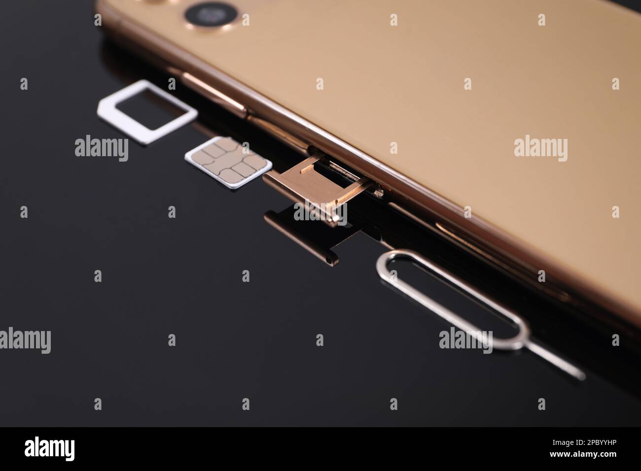 SIM card, smartphone and ejector on black background, closeup Stock