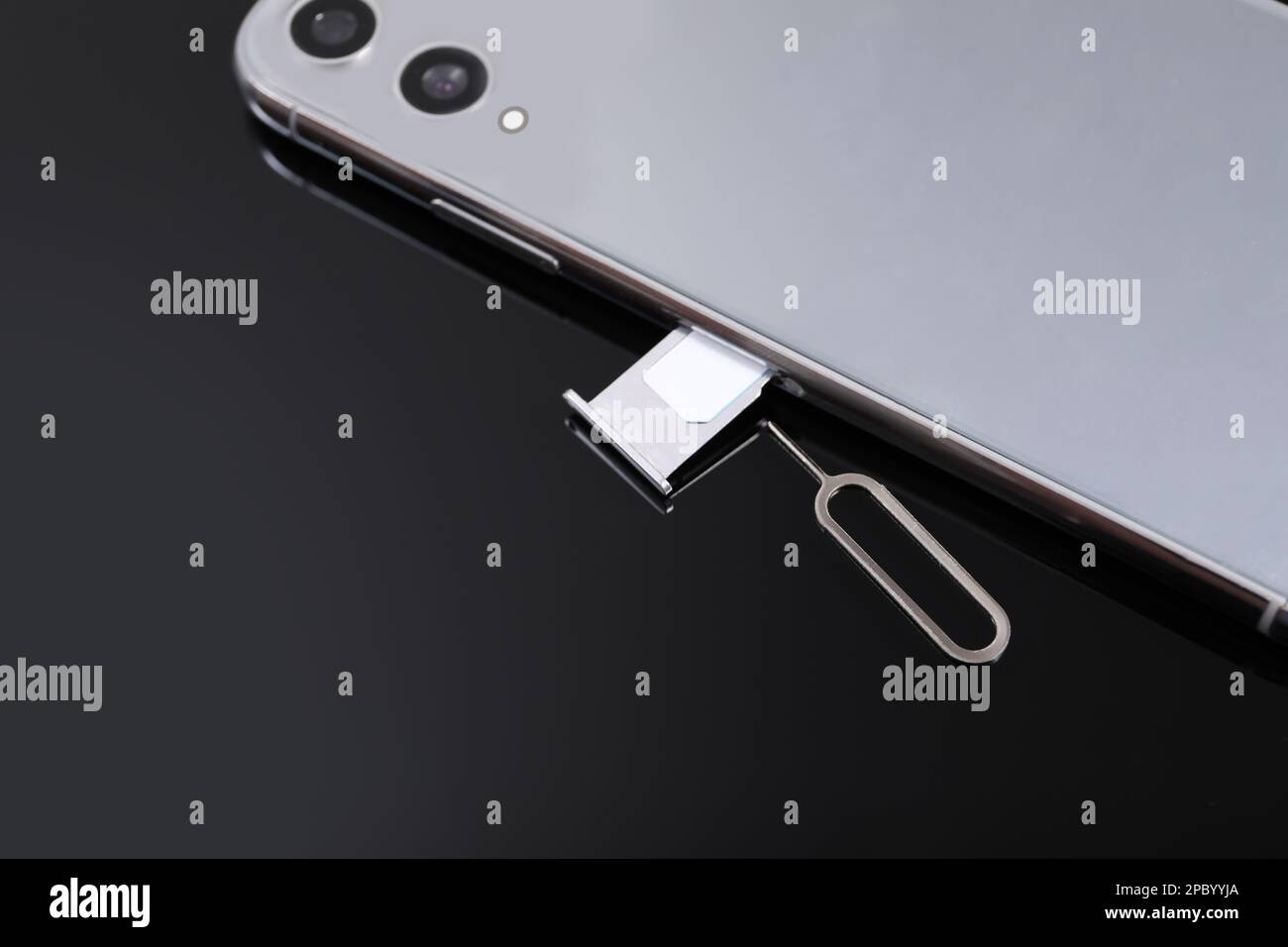 SIM card, smartphone and ejector on black background, above view Stock Photo
