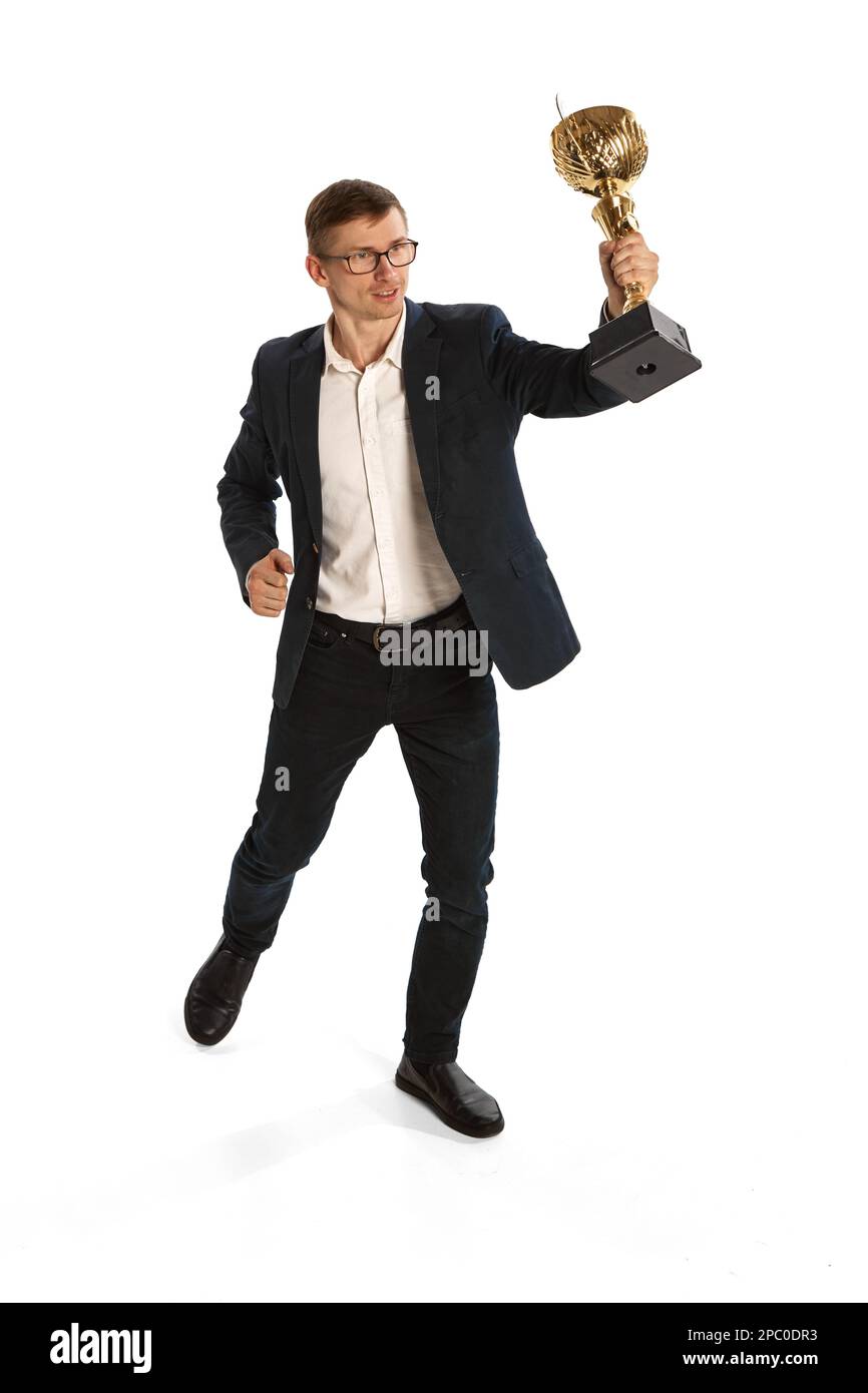 Young happy man holding award, trophy isolated over white background