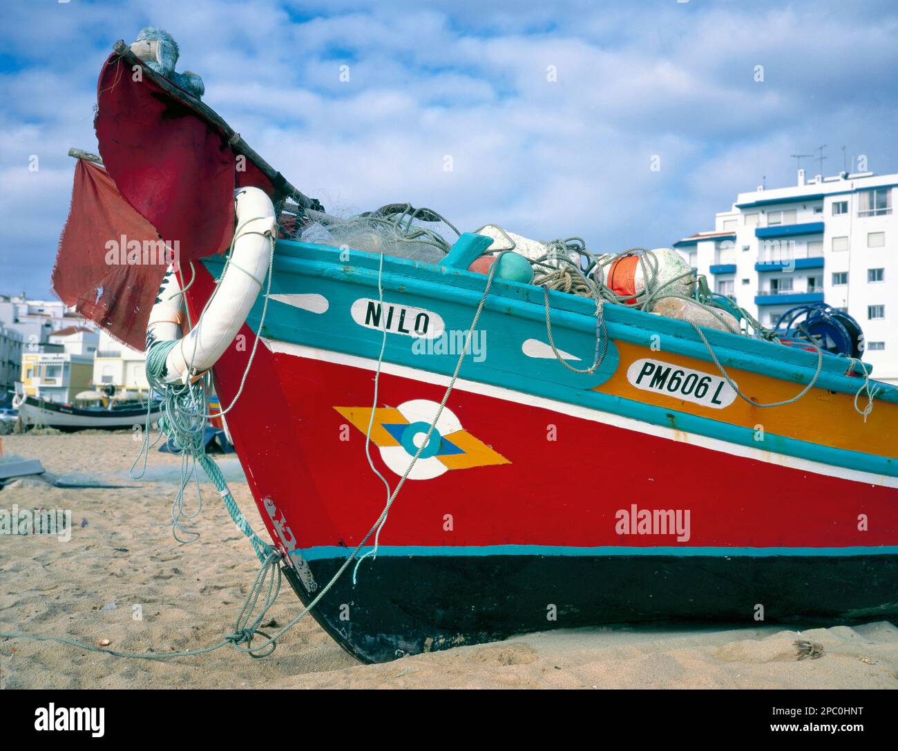 PORTIMAO,PORTUGAL-JANUARY 04 2019: Colorful wooden Fishing Boat on the beach with at the background holiday apartments Stock Photo