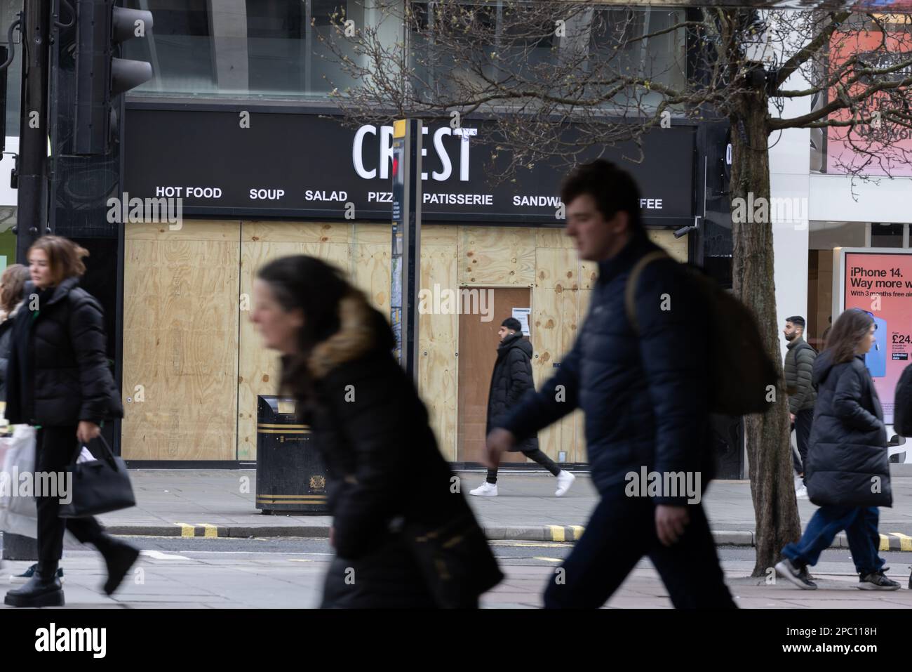 Shoppers walk past a boarded up shopfront on Oxford Street, as the retail sector struggles with high inflation and the fallout from Brexit and Covid. Stock Photo