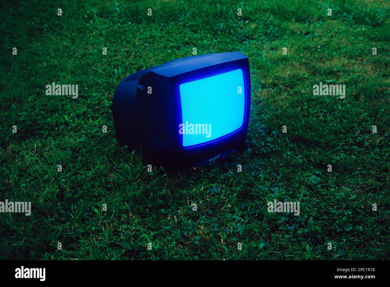 Old tv on grass Stock Photo