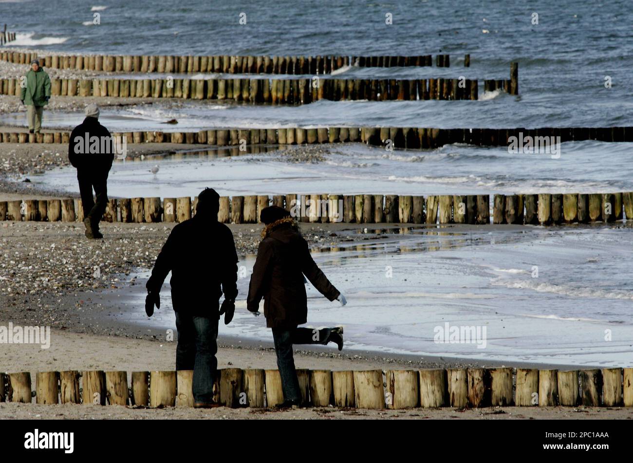 Spaziergaenger wandern am Montag, 5.Februar 2007, am Strand von Hohwacht an  der Ostsee entlang. Die Sonne sorgt im Norden fuer Temperaturen um die  sechs Grad Celsius. (AP Photo/Heribert Proepper) ---Strollers walk anlong