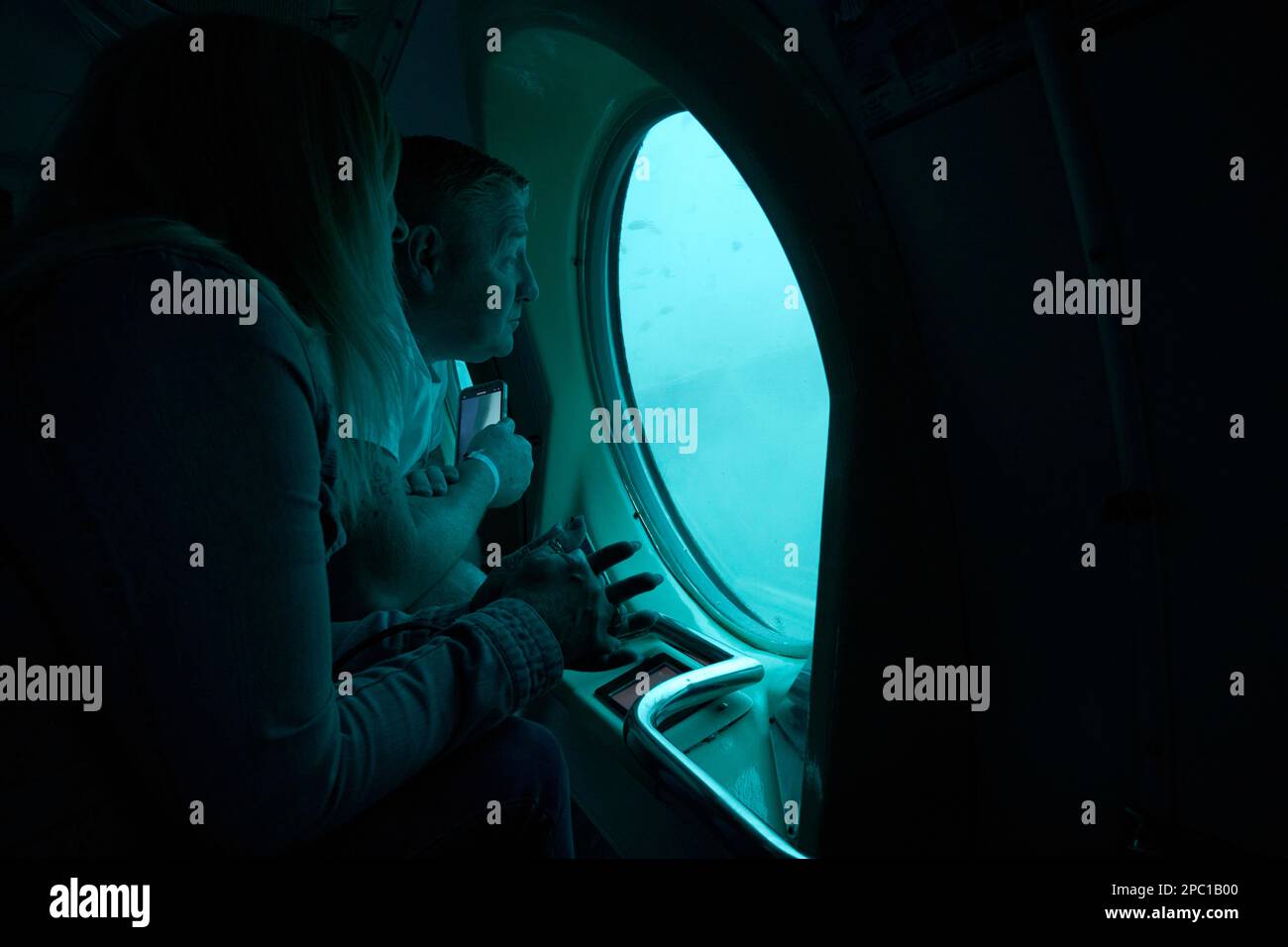 english tourists aboard the submarine safaris submarine out of puerto calero looking out of the window pointing Lanzarote, Canary Islands, Spain Stock Photo