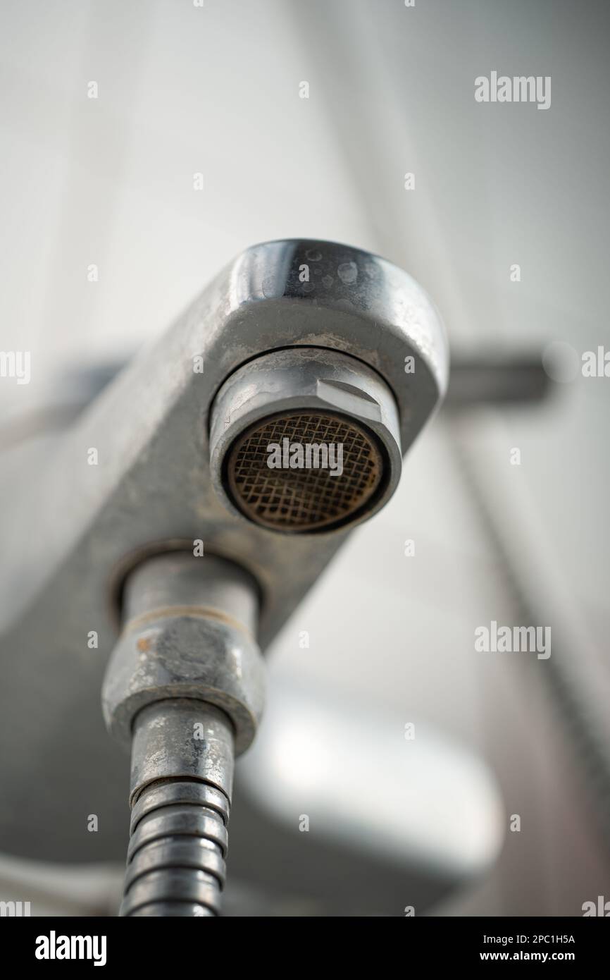 Old lime scale or calcium stained bathtub faucet from hard water. Close