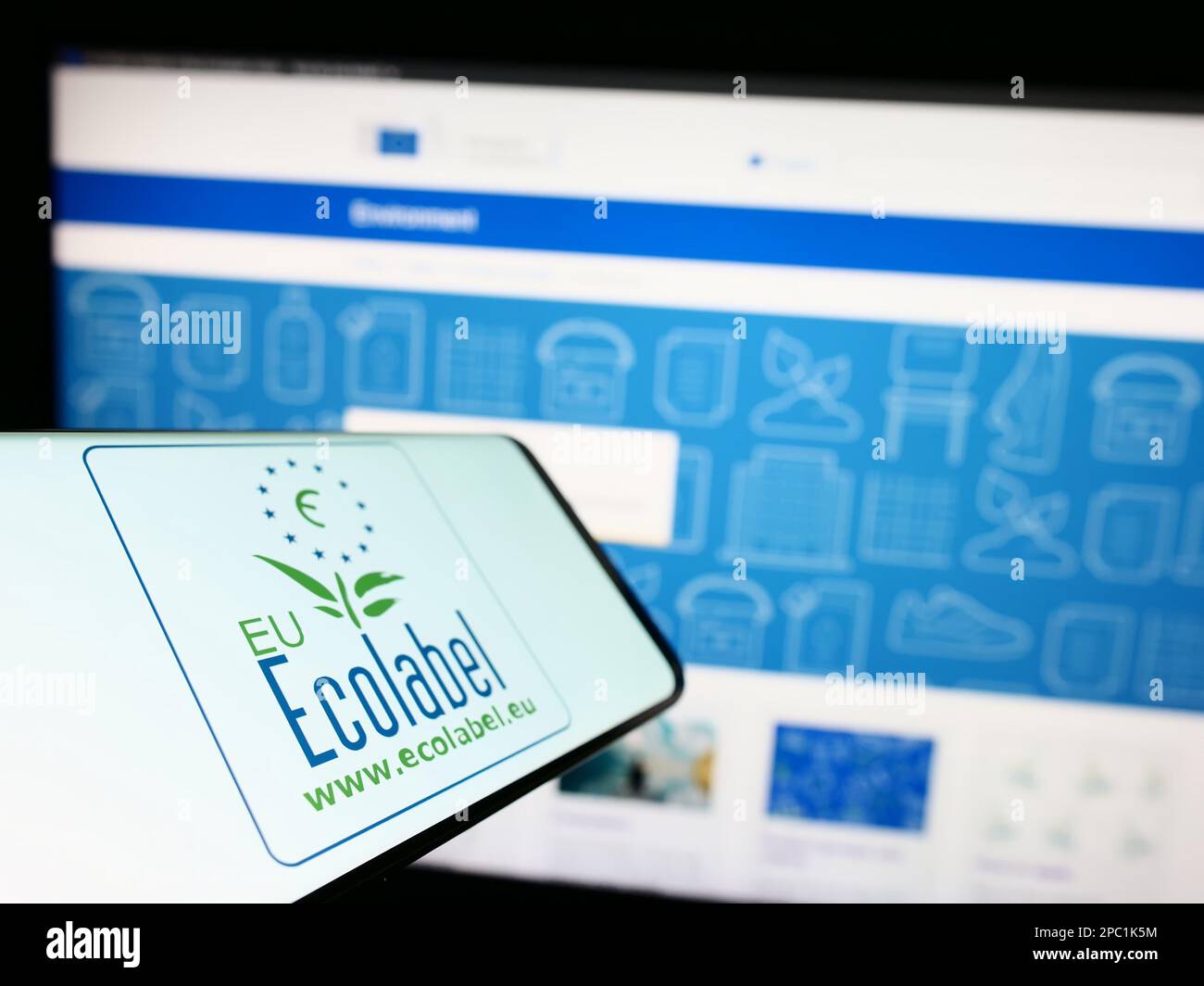 Smartphone with logo of environmental certification EU Ecolabel on screen in front of website. Focus on left of phone display. Stock Photo