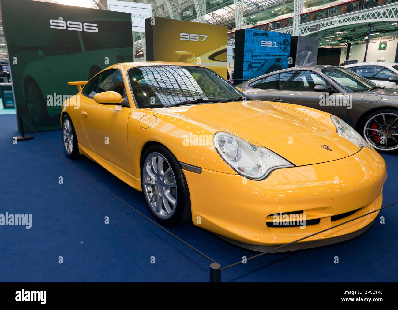 Three-quarters Front View of a Yellow, Porsche 996 part of a special celebration of 60 years of his famous marque, at the 2023 London Classic Car Show Stock Photo